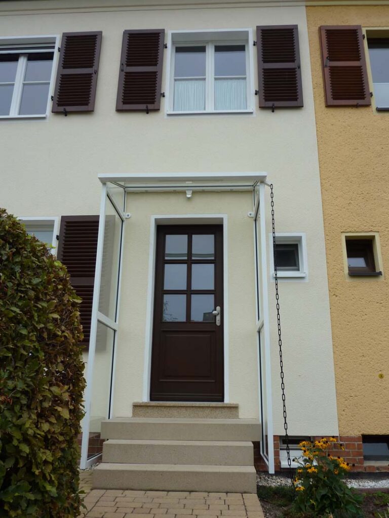 Alu-Vordach mit Seitenteilen, Holz-Haustür und Klappläden